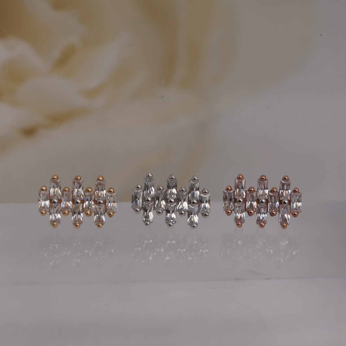 Front view of Buddha Jewelry’s “Imagine” in 14k yellow, white, and rose gold, featuring a tight cluster of elongated crystals in a repeating pattern.