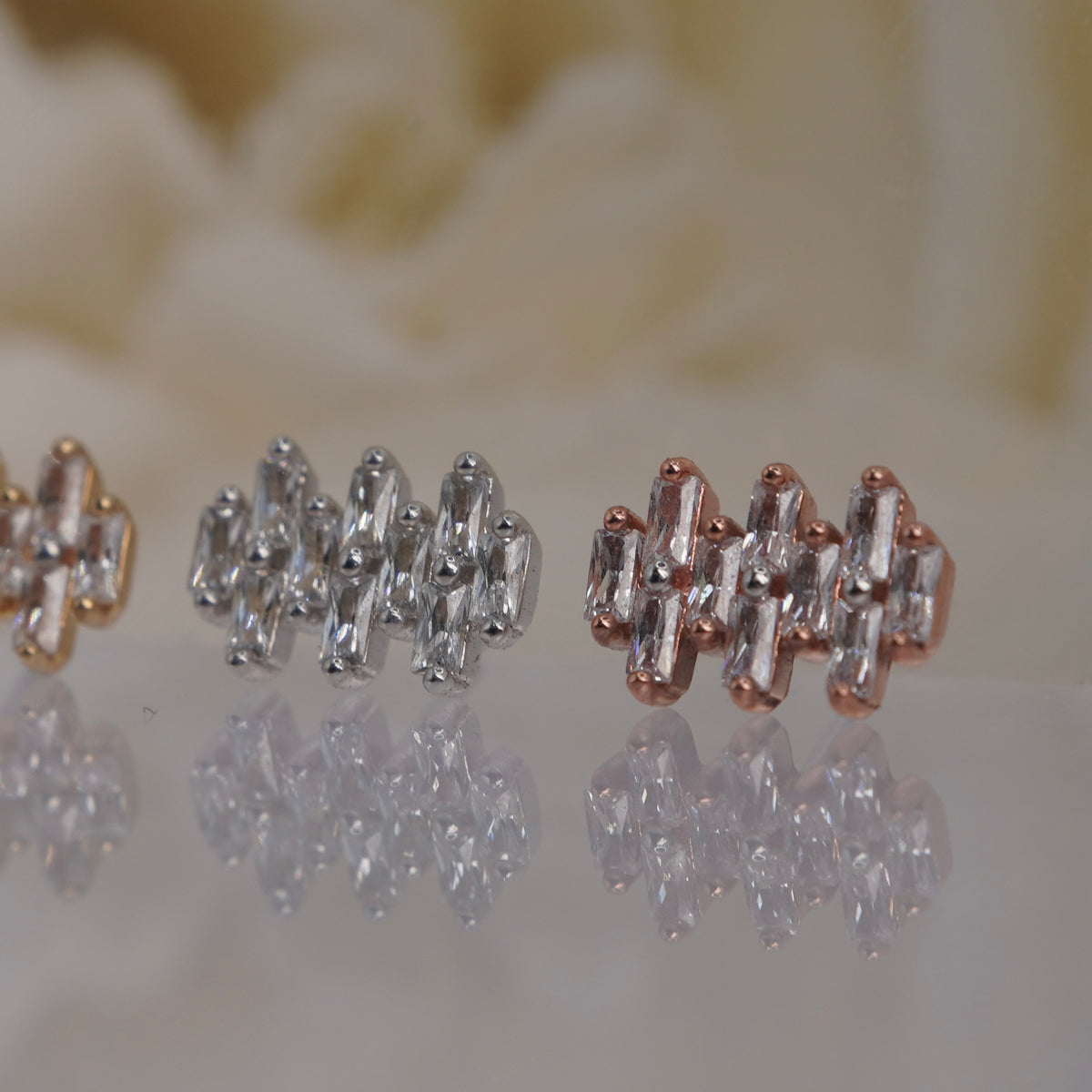 Angled view of Buddha Jewelry’s “Imagine” in 14k yellow, white, and rose gold, showing the dimensional crystal cluster and woven appearance.