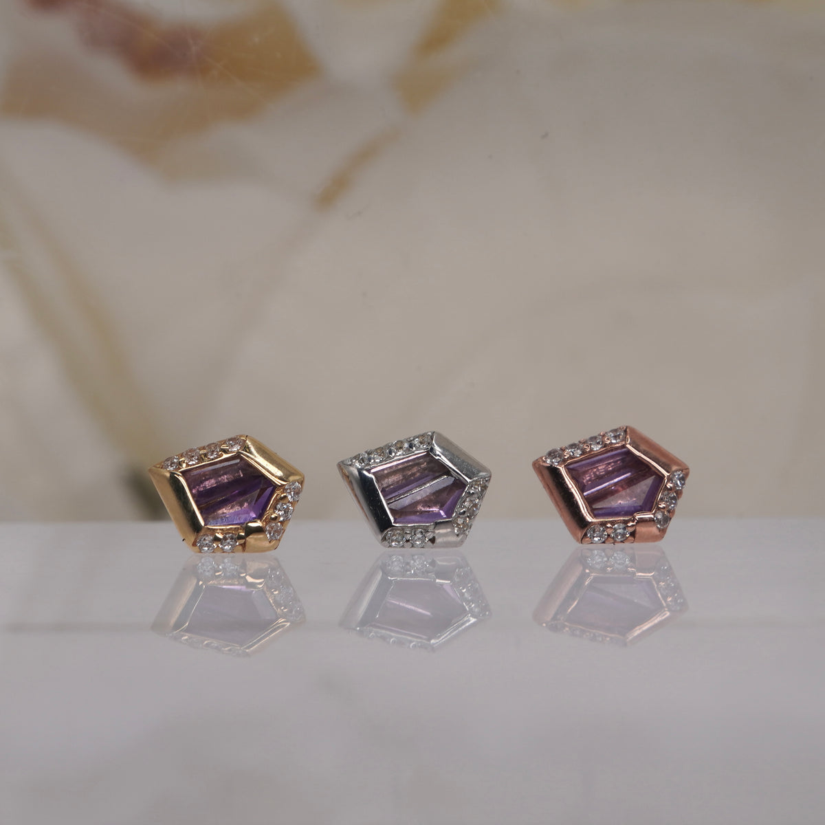 Front view of Buddha Jewelry’s “Route” with Amethyst in 14k yellow, white, and rose gold, featuring a fancy-cut amethyst framed by geometric goldwork and a crystal halo.