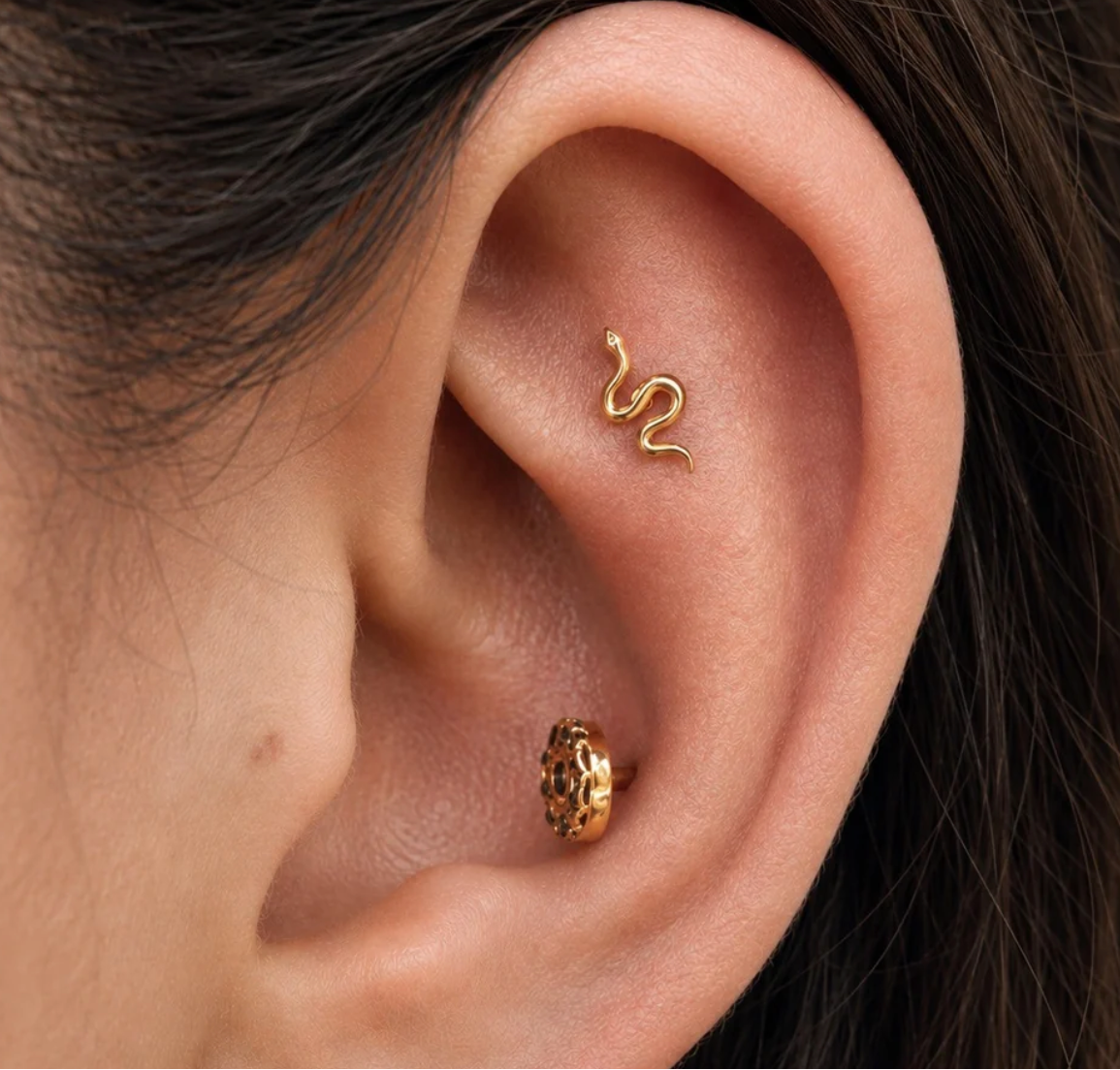 Buddha Jewelry’s “Serpent” worn in an ear piercing, showing its winding silhouette following the natural curve of the ear.