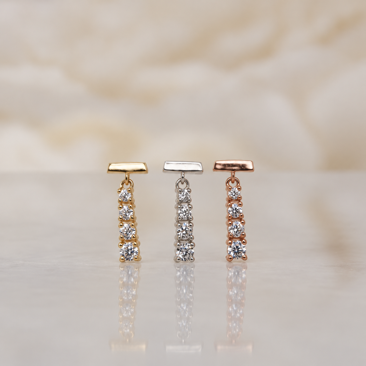 Front view of “Requiem” in 14k yellow, white, and rose gold, featuring four prong-set round stones that gradually taper in size.