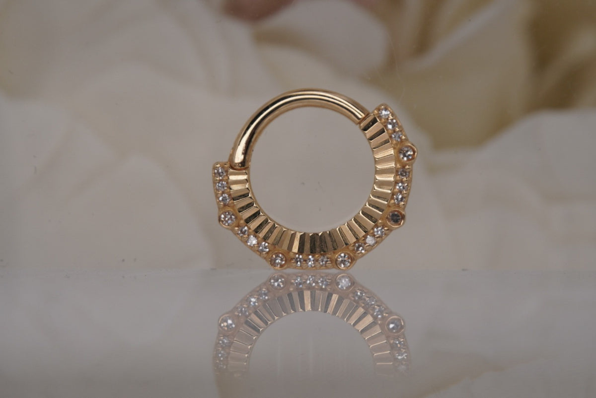 Front view of the yellow gold Awaken clicker with genuine diamonds and sunburst-like texture.