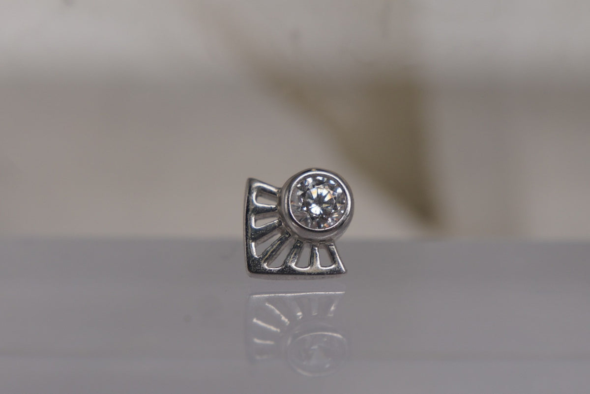 Front view of Buddha Jewelry’s “Dali” in 14k white gold, featuring a bezel-set crystal framed by radiating angular lines.