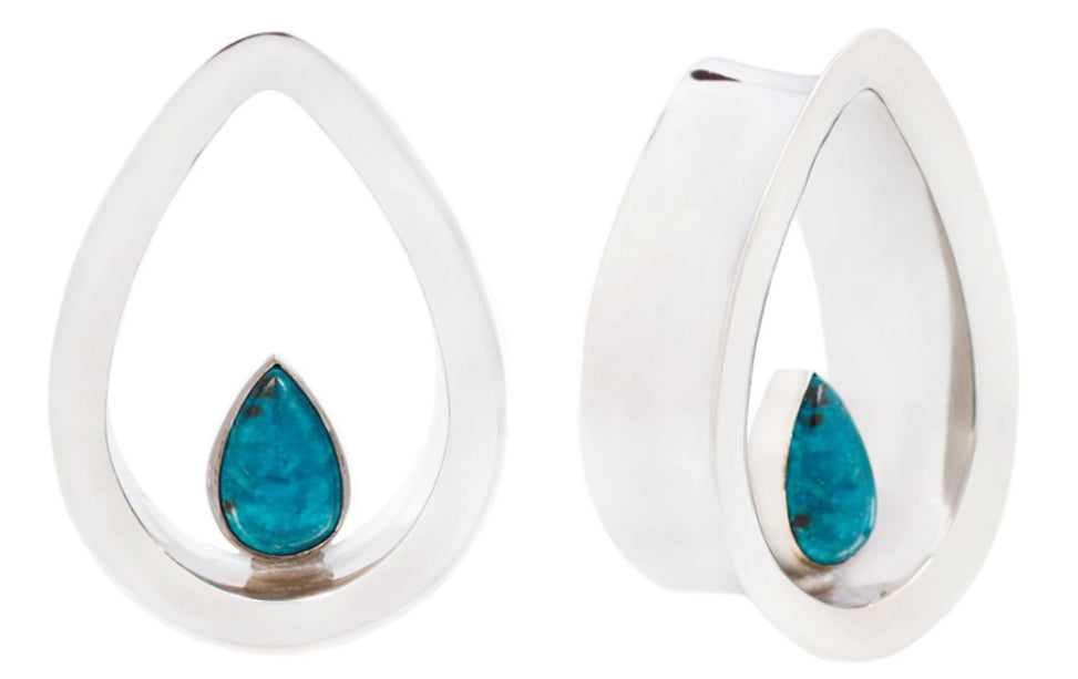 A pair of silver-toned teardrop-shaped earrings with a small teardrop turquoise gemstone in the center, shown against a plain white background.