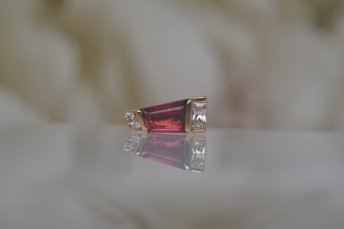 Front view of Buddha Jewelry’s “Saboteur” with Pink Tourmaline in 14k yellow gold, featuring a rosy tapered baguette stone with sparkling crystal accents.