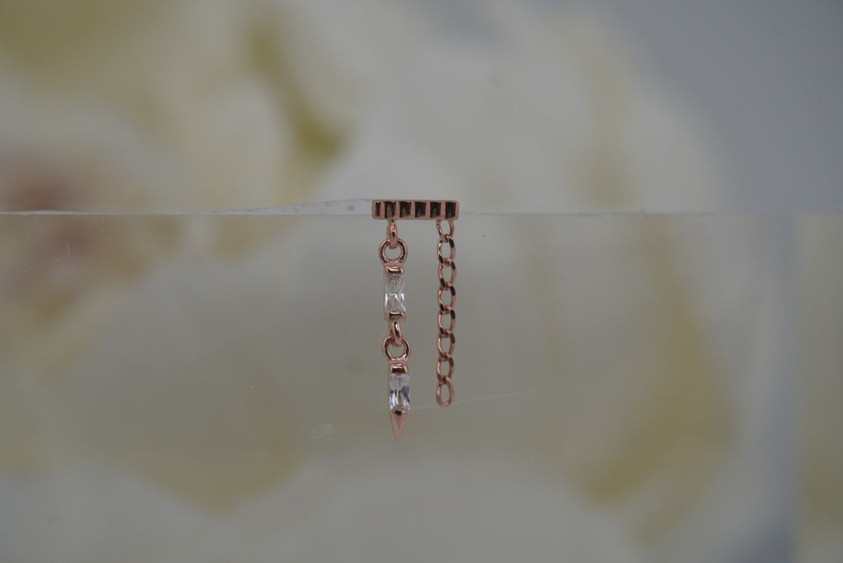 Front view of Buddha Jewelry’s “Double Vision” in 14k rose gold, featuring a ribbed top bar, vertical crystal row, pointed spike, and delicate side chain.