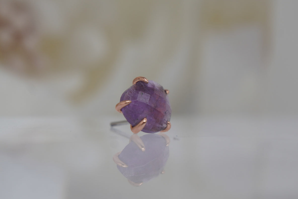 Angled view showing the amethyst and delicate rose gold prongs.