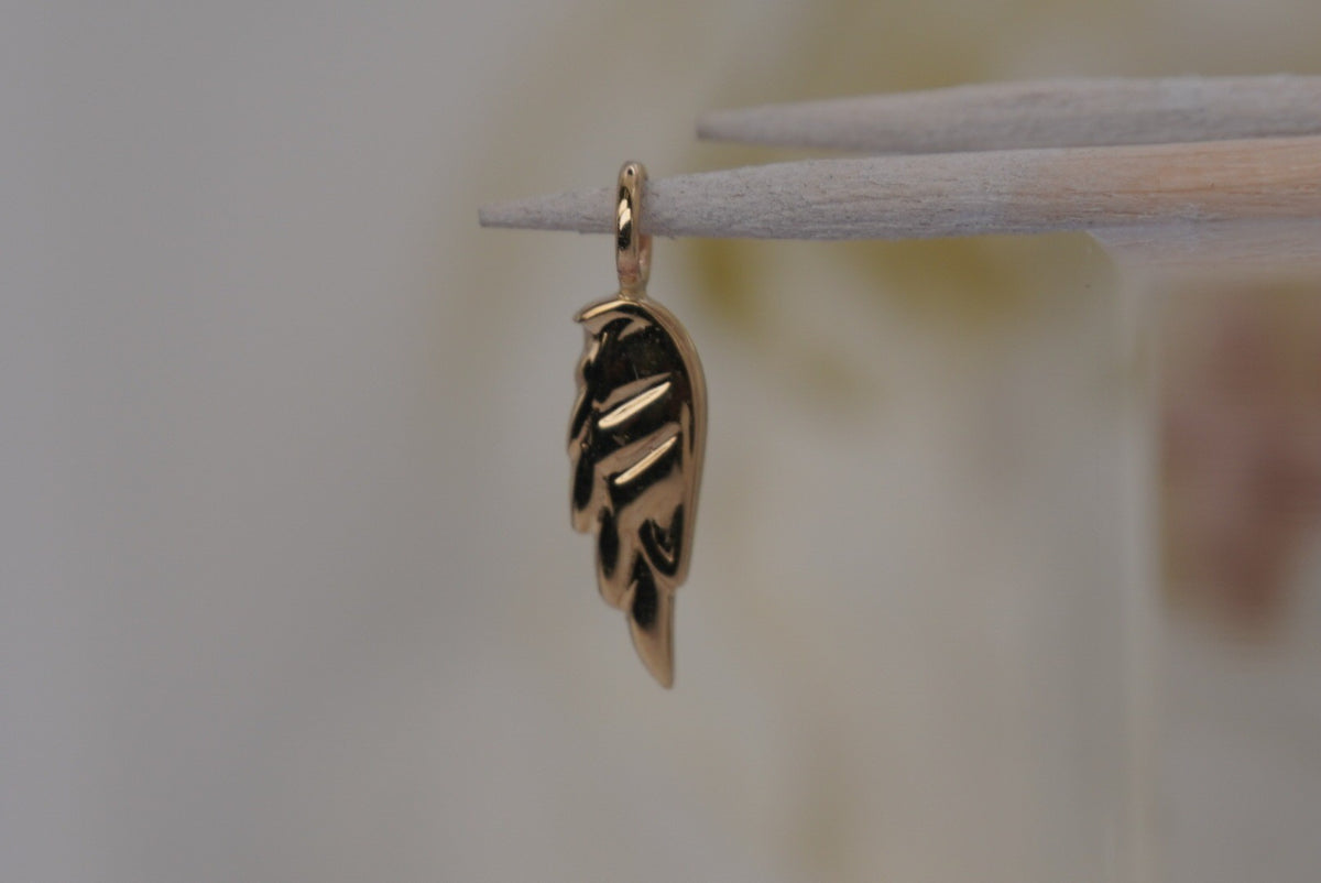 Side Facing Norvoch 14k Angel Wing Charm pendant in Yellow gold piercing charm, front view