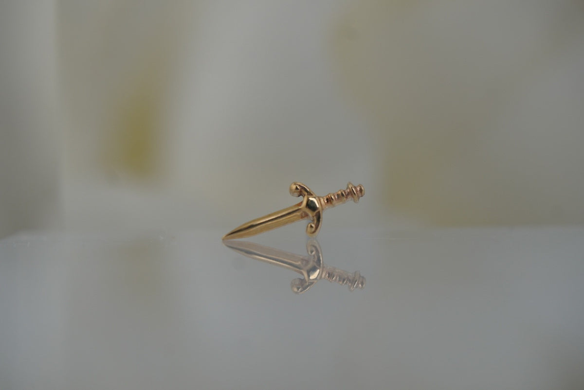 Front view of Buddha Jewelry’s “Blade” in 14k yellow gold, featuring a sleek, elongated sword silhouette with a polished finish.