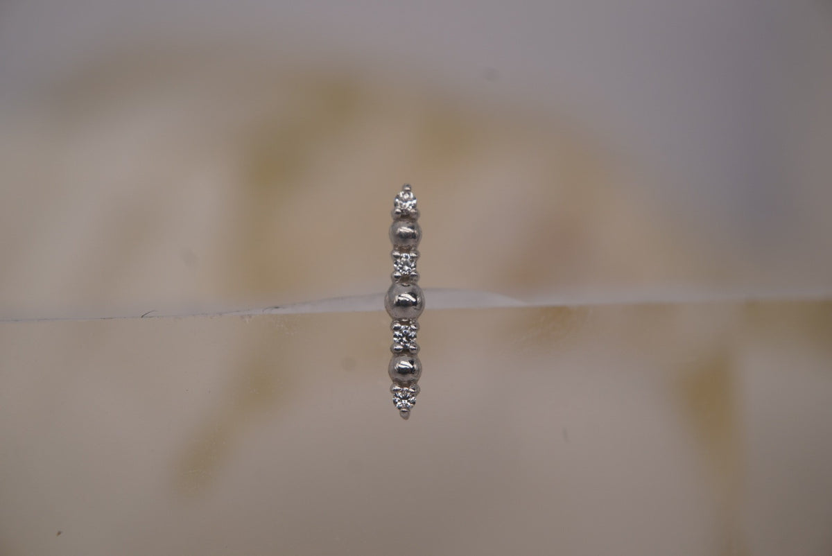 Front view of Buddha Jewelry’s “Chance” in 14k white gold, featuring alternating polished beads and shimmering crystals in a slim vertical arrangement.