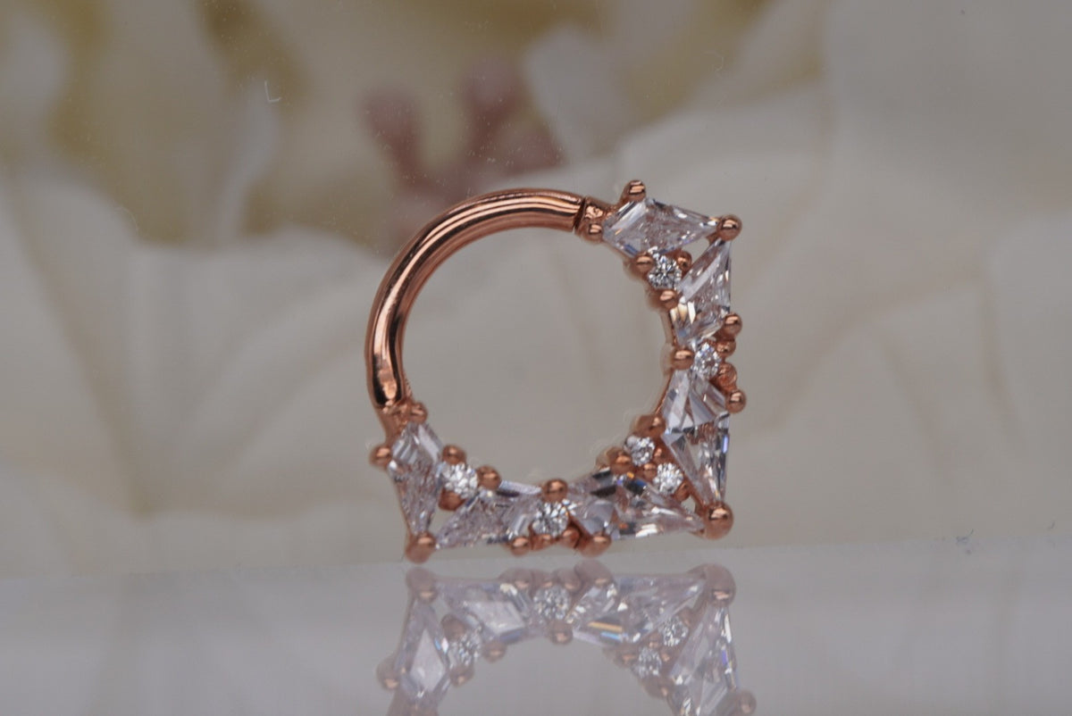 Front view of Buddha Jewelry’s “Legacy” clicker in 14k rose gold, featuring an ornate arc of faceted crystals in layered shapes.