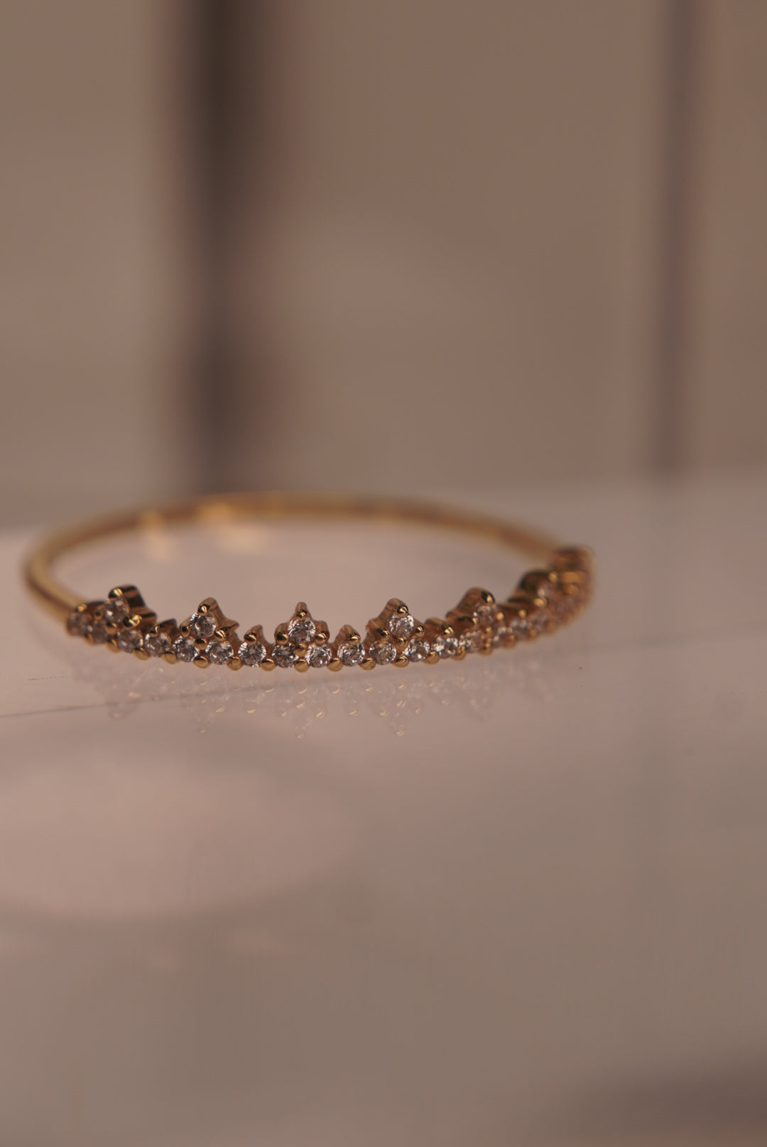 Angled view showing the ring’s crystal settings and gold band.