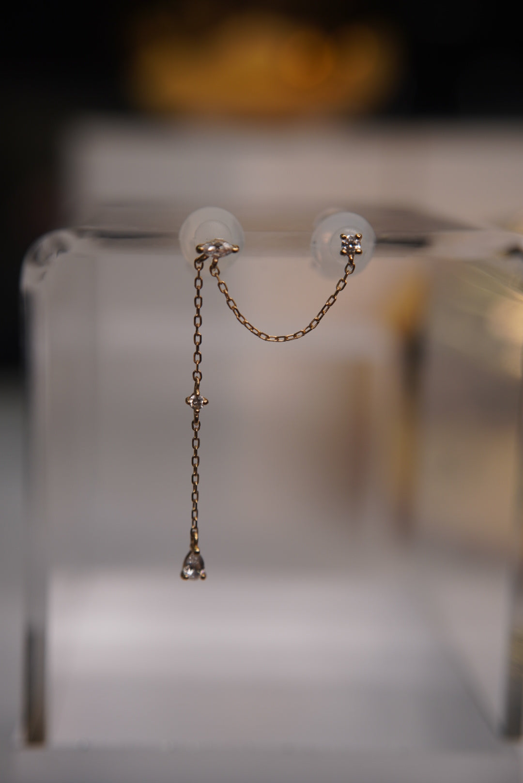 Two 14k yellow gold threadless ends connected by a long drop chain with white CZ accents.