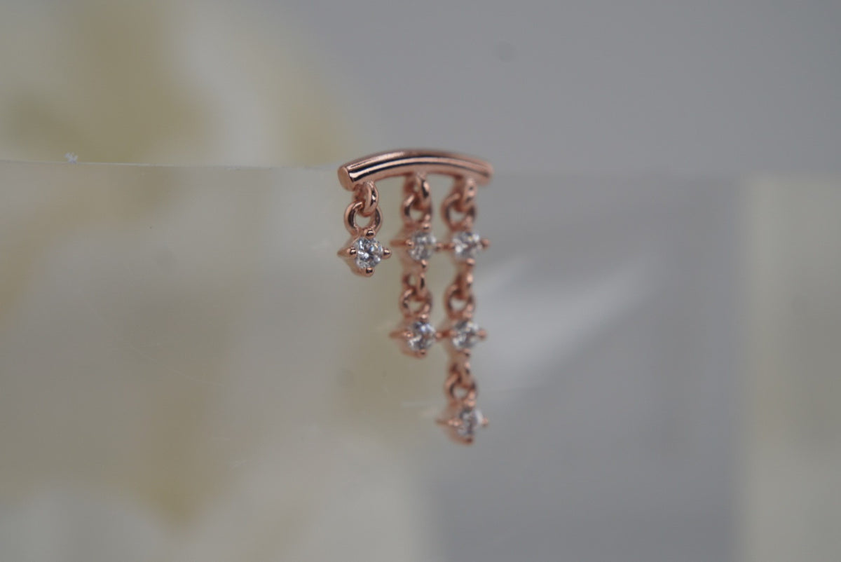 Angled view of And Beyond in rose gold with three crystal-accented chains.