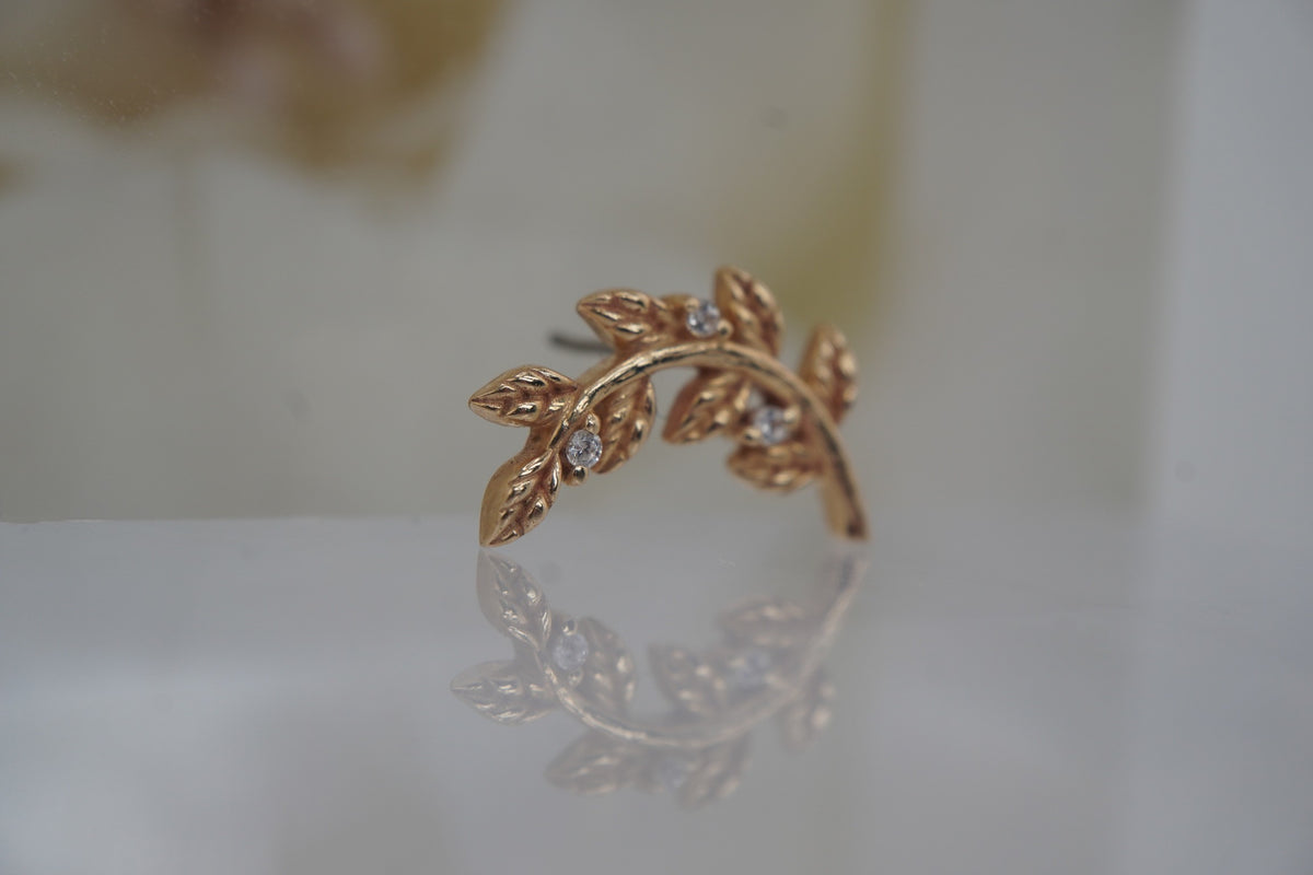 Angled view showing the sculptural gold branch and crystal settings.