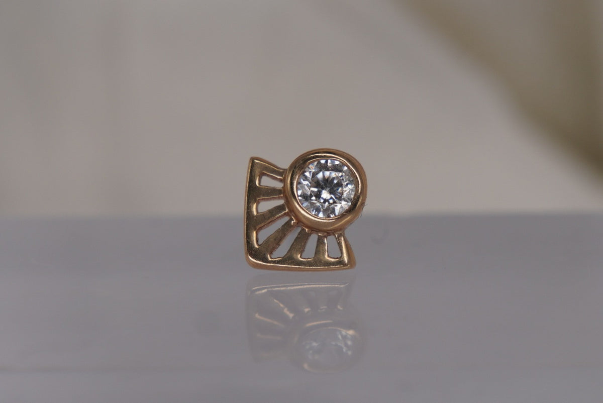Front view of Buddha Jewelry’s “Dali” in 14k yellow gold, featuring a bezel-set crystal framed by radiating angular lines.