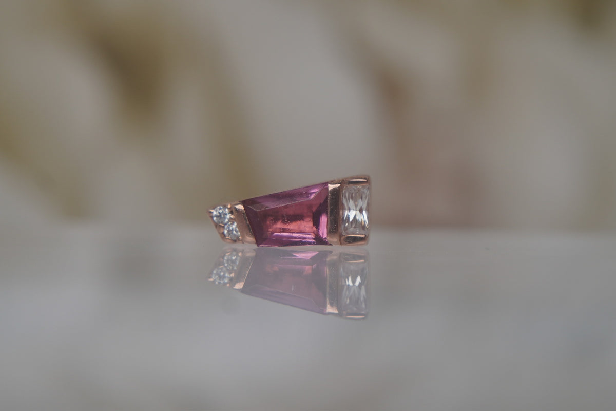 Front view of Buddha Jewelry’s “Saboteur” with Pink Tourmaline in 14k rose gold, featuring a rosy tapered baguette stone with sparkling crystal accents.