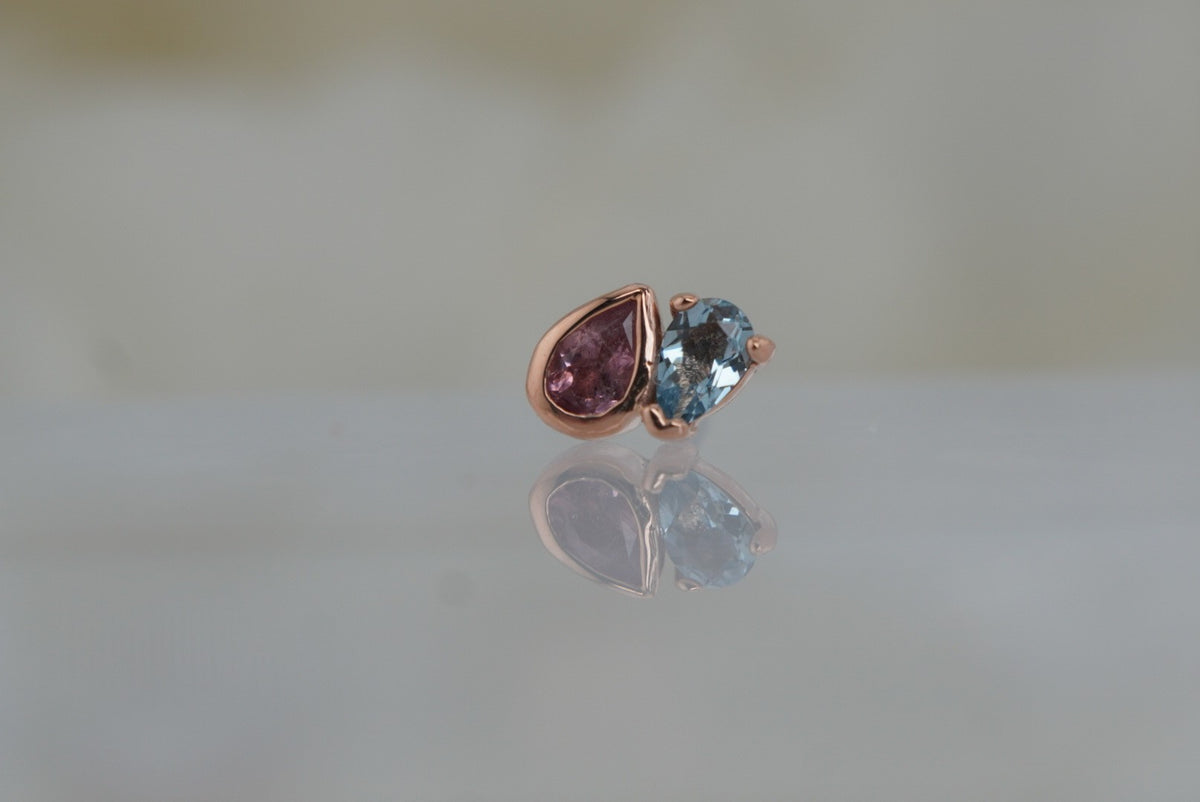 Front view of Buddha Jewelry’s “Era” in 14k rose gold, featuring pear-cut pink tourmaline paired with London Blue Topaz.