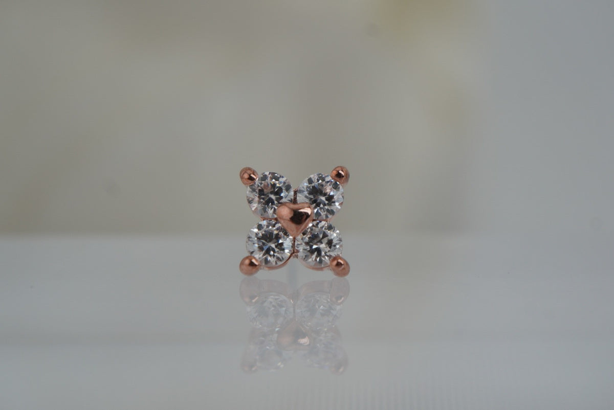 Front view of Buddha Jewelry’s “Corazon” in 14k rose gold, featuring four shimmering crystals arranged around a polished gold heart.
