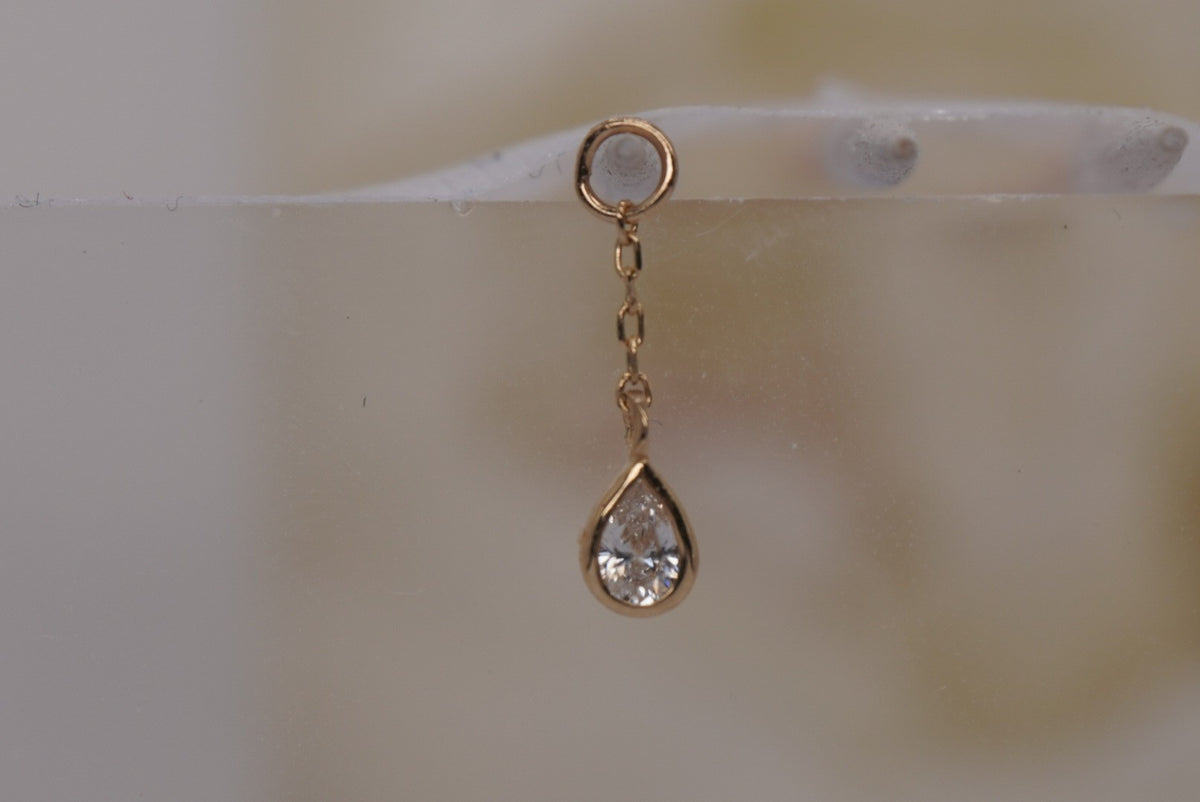 Front view of Buddha Jewelry’s “Concorde Chain” in 14k yellow gold, featuring a fine chain leading to a faceted white topaz drop.