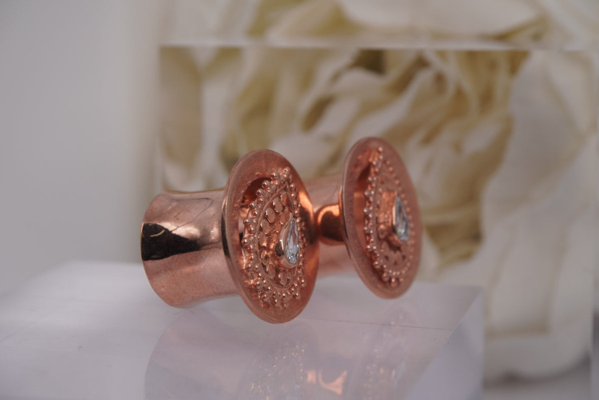 Side view of Buddha Jewelry’s “Deity Plug” in rose gold, highlighting the luminous crystal and dimensional beadwork.