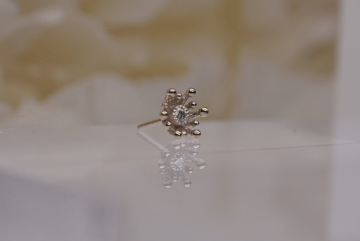 14k gold “Fire Star” threadless end in white gold, angled view