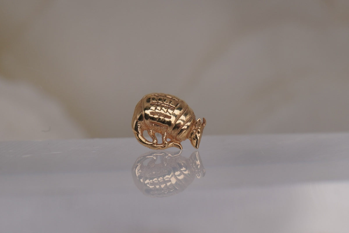 Front view of Buddha Jewelry’s “Let’s Roll” in 14k yellow gold, featuring a curved armadillo design with a textured shell.