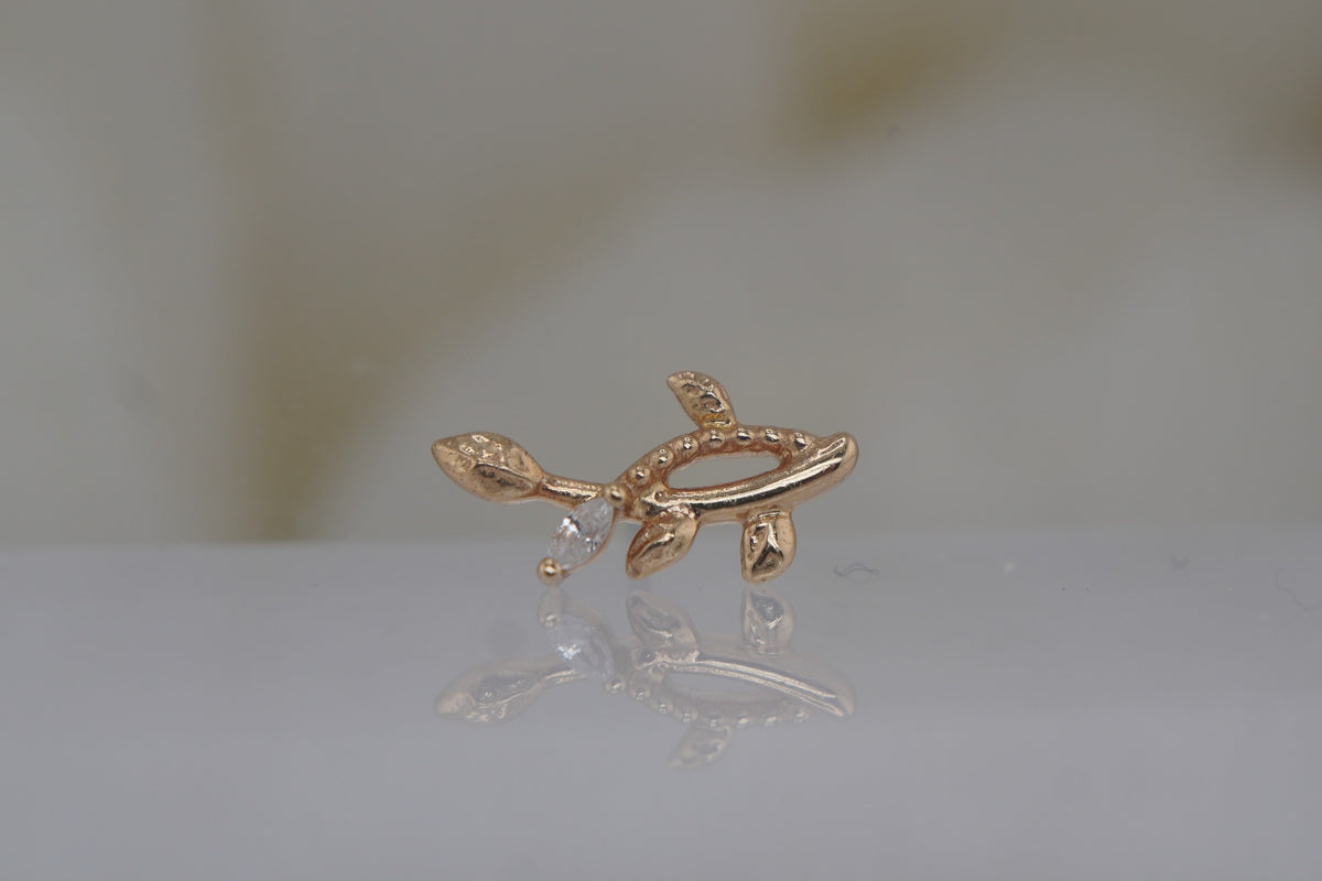 Angled view showing the textured gold leaves and crystal setting.