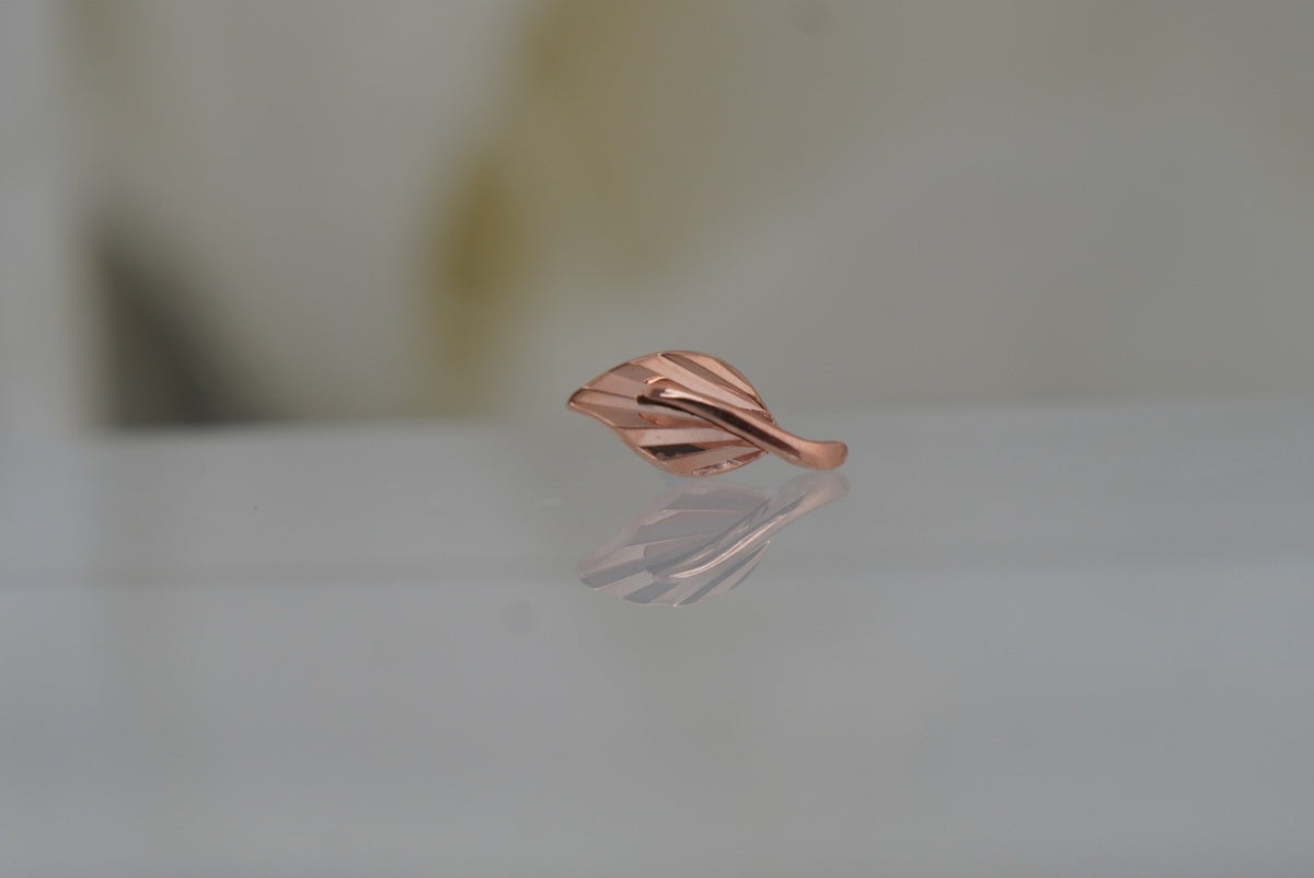 Front view of Buddha Jewelry’s “Essence” in 14k rose gold, featuring a delicate leaf design with flowing, polished lines.