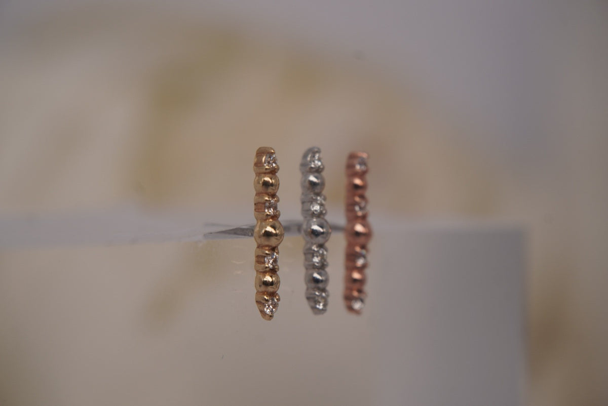 Angled view of Buddha Jewelry’s “Chance” in 14k yellow, white, and rose gold, highlighting the rounded beads, sparkling crystals, and elongated silhouettes.