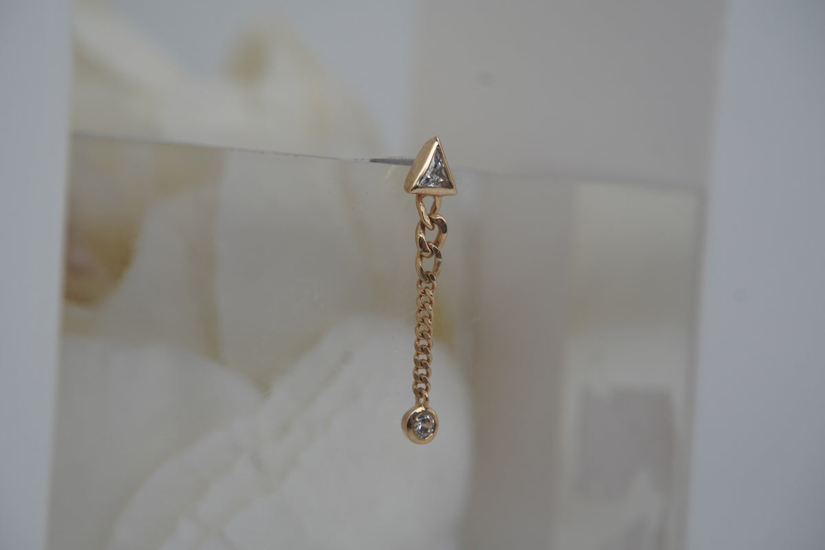 Side view of the elongated design, showing its hanging chain and crystal setting.