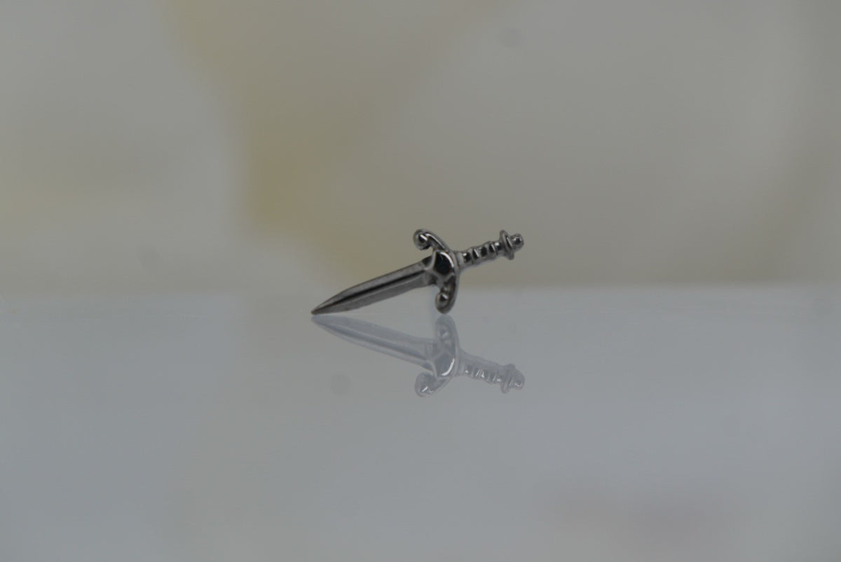 Front view of Buddha Jewelry’s “Blade” in 14k black rhodium, featuring a sleek, elongated sword silhouette with a polished finish.